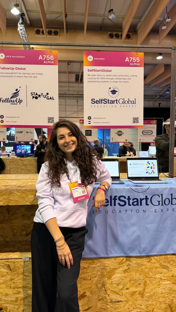 Radmila by the SelfStartGlobal stand at a startup event.