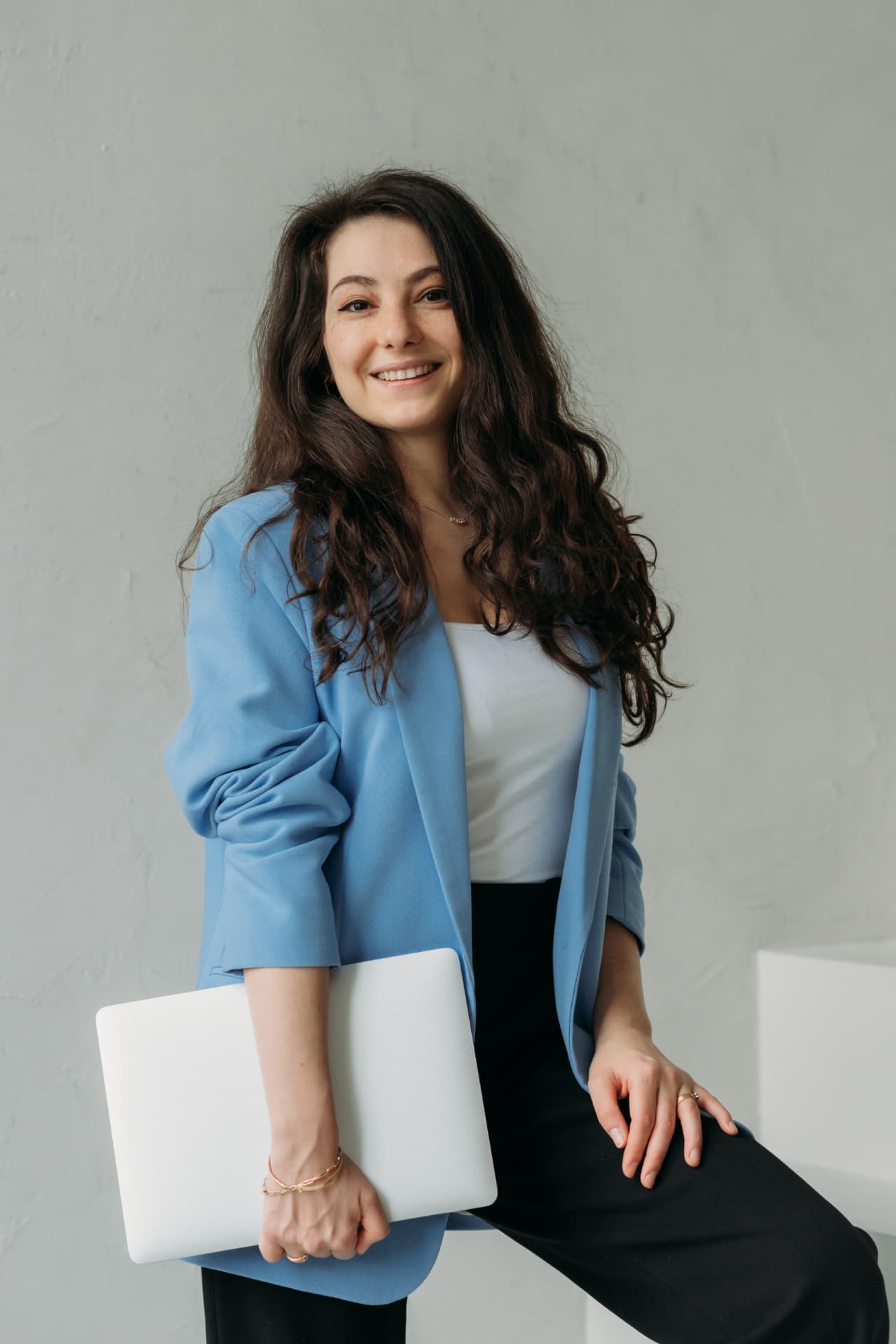 Radmila, founder of SelfStartGlobal, holding a laptop.