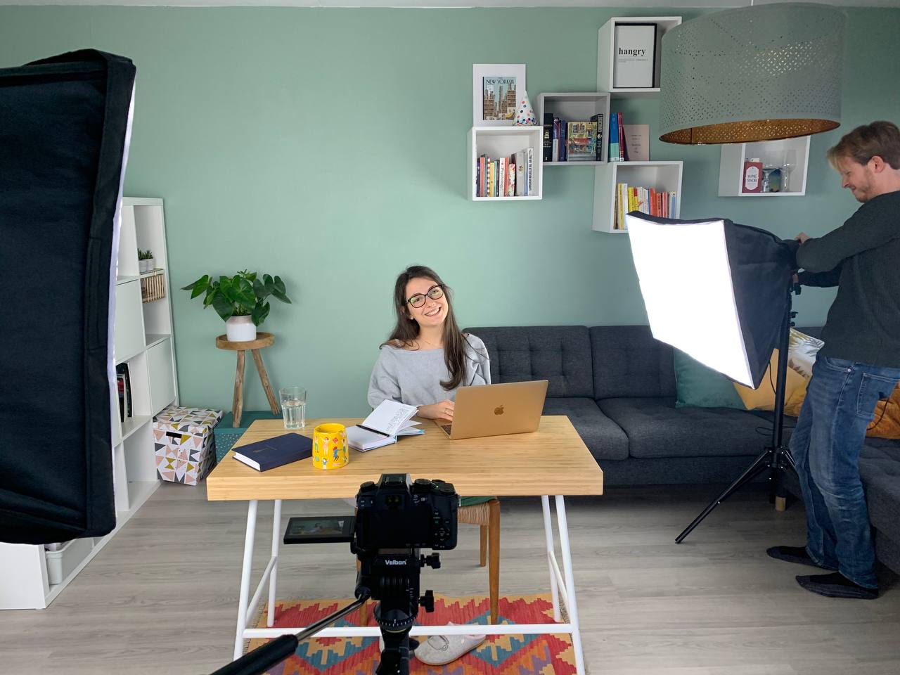 Radmila at a desk with a laptop during filming.